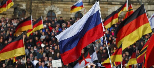 Supporters of the anti-Islam movement Patriotic Europeans Against the Islamisation of the West (PEGIDA) carry German and Russian flags during a demonstration in Dresden, Germany, February 6, 2016 - Sputnik International