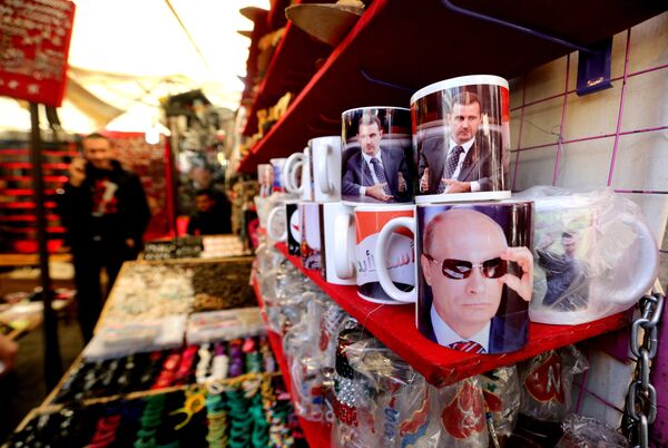 A Syrian vendor sells mugs bearing portraits of Russian President Vladimir Putin (bottom) and Syrian President Bashar Assad (top) in the popular Hamidiyeh market in the old part of the capital Damascus on November 26, 2015 - Sputnik International