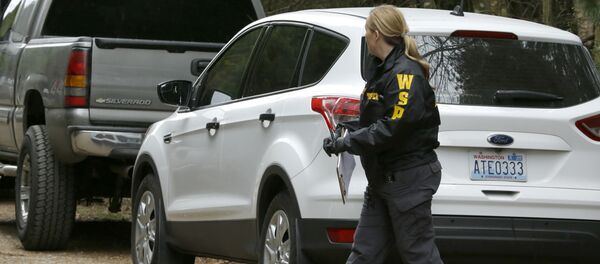 Washington State Patrol detective walks with protective foot covers on near the scene of a fatal shooting Friday, Feb. 26, 2016, near Belfair, Wash - Sputnik International