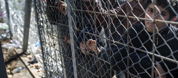 Migrants from Syria wait to cross the Greek-Macedonian border near the town of Gevgelija on February 27, 2016 - Sputnik International