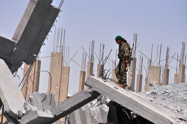 A female fighter from the Kurdish People Protection Unit (YPG) looks at destruction in the Syrian town of Ain Issi, some 50 kilometres north of Raqqa (File) A female fighter from the Kurdish People Protection Unit (YPG) looks at destruction in the Syrian town of Ain Issi, some 50 kilometres north of Raqqa (File) - Sputnik International