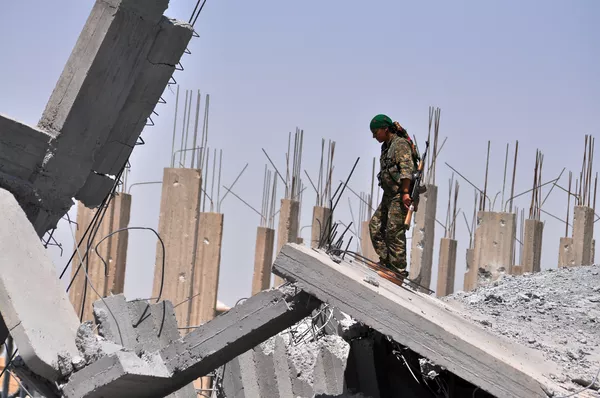 A female fighter from the Kurdish People Protection Unit (YPG) looks at destruction in the Syrian town of Ain Issi, some 50 kilometres north of Raqqa (File) A female fighter from the Kurdish People Protection Unit (YPG) looks at destruction in the Syrian town of Ain Issi, some 50 kilometres north of Raqqa (File) - Sputnik International