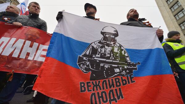 Participants of a rally in Moscow carrying a banner depicting a Russian special forces operator; the caption reads 'Polite People'. - Sputnik International
