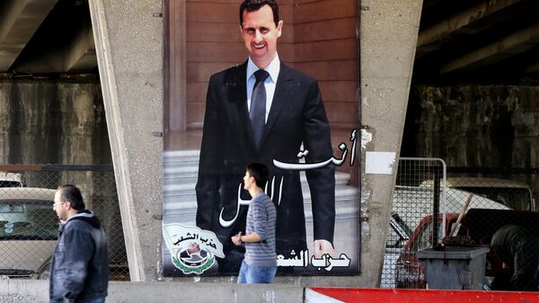 Syrian men walk past a poster bearing a portrait of President Bashar al-Assad in the capital Damascus, on February 27, 2016, as the first major ceasefire of the five-year war takes hold and an international task force prepares to begin monitoring the landmark truce - Sputnik International