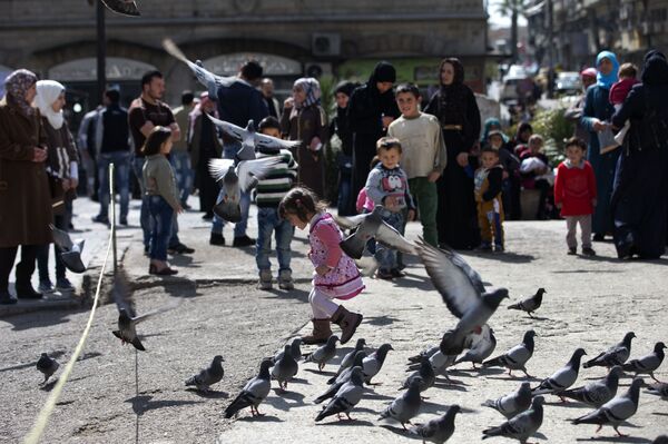 A Syrian girl chases pigeons in Marjeh Square, in Damascus, Syria, Saturday, Feb. 27, 2016 A Syrian girl chases pigeons in Marjeh Square, in Damascus, Syria, Saturday, Feb. 27, 2016 - Sputnik International