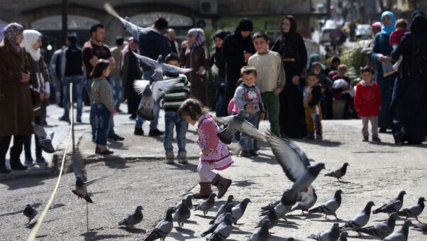 A Syrian girl chases pigeons in Marjeh Square, in Damascus, Syria, Saturday, Feb. 27, 2016 - Sputnik International