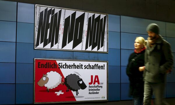 A poster of Swiss People's Party (SVP), demanding to vote for an initiative to deport criminal foreigners, is placed underneath another one against it at the central railway station in Zurich, Switzerland in this February 12, 2016 file photo - Sputnik International