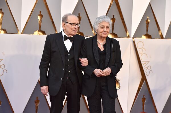 Ennio Morricone, left, and Maria Travia arrive at the Oscars on Sunday, Feb. 28, 2016, at the Dolby Theatre in Los Angeles. Ennio Morricone, left, and Maria Travia arrive at the Oscars on Sunday, Feb. 28, 2016, at the Dolby Theatre in Los Angeles. - Sputnik International