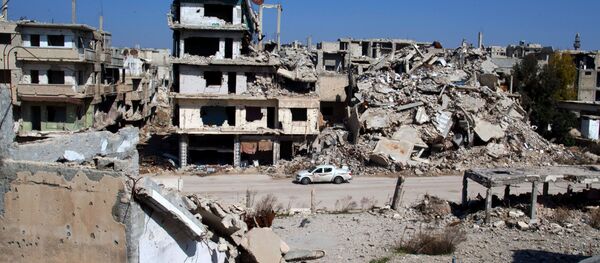 In this picture taken Friday, Feb. 26, 2016, a car drives through a devastated part of the old city of Homs, Syria - Sputnik International