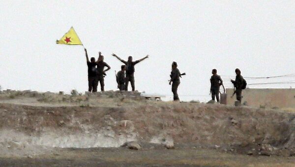 In this Monday, June 15, 2015 file photo taken from the Turkish side of the border between Turkey and Syria, in Akcakale, southeastern Turkey, Kurdish fighters with the Kurdish People's Protection Units, or YPG, wave their yellow triangular flag in the outskirts of Tal Abyad, Syria - Sputnik International
