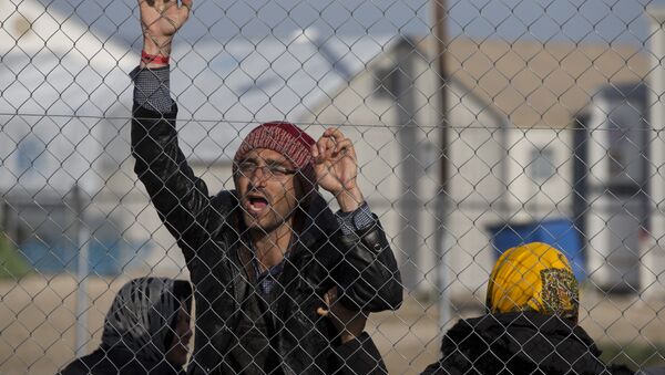 Afghan migrant shouts Merkel help us in the northern Greek border station of Idomeni , Tuesday, Feb. 23, 2016 - Sputnik International