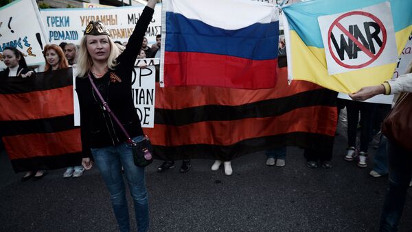 People hold Russian and Ukrainian flags tied together bearing an anti-war symbol (File) - Sputnik International