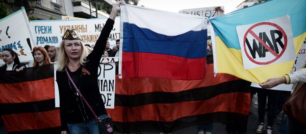 People hold Russian and Ukrainian flags tied together bearing an anti-war symbol (File) People hold Russian and Ukrainian flags tied together bearing an anti-war symbol (File) - Sputnik International