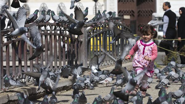 A Syrian girl chases pigeons in Marjeh Square, Damascus, Syria, Saturday, Feb. 27, 2016 - Sputnik International