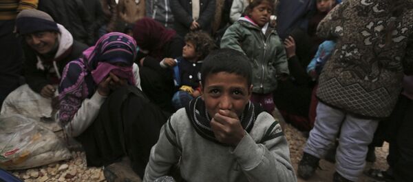 Syrians gather at the Bab al-Salam border gate with Turkey, in Syria, Saturday, Feb. 6, 2016 - Sputnik International
