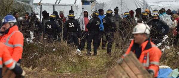 Agents dismantle a shelter as anti-riot policemen stand nearby on February 29, 2016 in the jungle migrants and refugees camp in Calais, northern France - Sputnik International