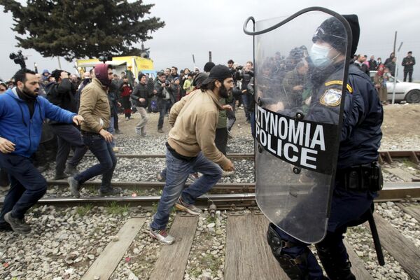 Stranded refugees and migrants try to break a Greek police cordon in order to approach the border fence at the Greek-Macedonian border, near the Greek village of Idomeni, February 29, 2016. Stranded refugees and migrants try to break a Greek police cordon in order to approach the border fence at the Greek-Macedonian border, near the Greek village of Idomeni, February 29, 2016. - Sputnik International