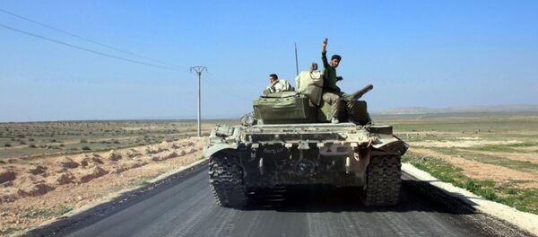 Syrian pro-government forces advance on a road through the town of Khanasser, which is the sole link between government-held areas in and around Aleppo and those in the rest of the country, after they reportedly recaptured it from Islamic State (IS) group fighters, on February 29, 2016. - Sputnik International