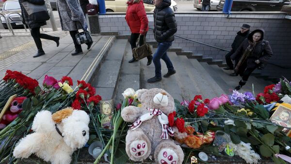 Flowers, toys and other items are placed to commemorate recently murdered child at the entrance to the Oktyabrskoye Pole metro station in Moscow, Russia, March 1, 2016. - Sputnik International