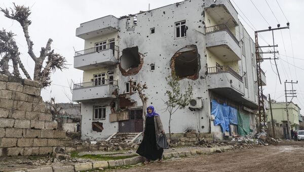A woman walks past the ruins of a building as curfew ends during daylight in the town of Silopi. (File) - Sputnik International