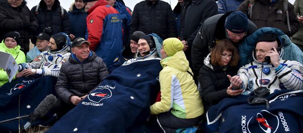 US astronaut Scott Kelly (R) and Russian cosmonauts Sergei Volkov (C) and Mikhail Korniyenko, surrounded by ground personnel, rest shortly after landing near the town of Dzhezkazgan (Zhezkazgan), Kazakhstan, March 2, 2016. - Sputnik International