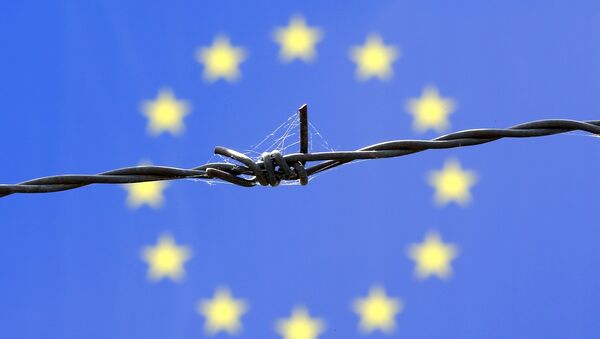 A barbed wire is seen in front of European Union flag - Sputnik International