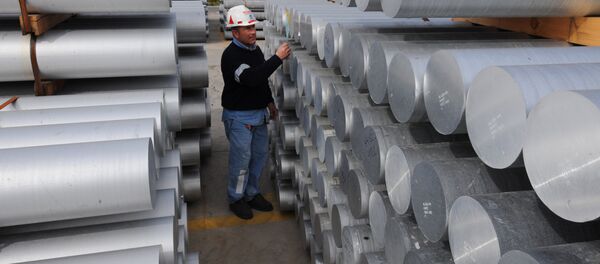 Aworker checks aluminium bars on February 15, 2010 at the US aluminium company Alcoa's plant in Portovesme. (File) - Sputnik International