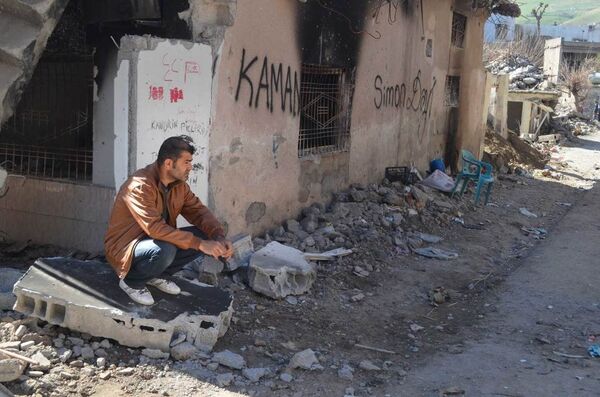 A resident of Cizre sits next to his ruined and burned house. A resident of Cizre sits next to his ruined and burned house. - Sputnik International