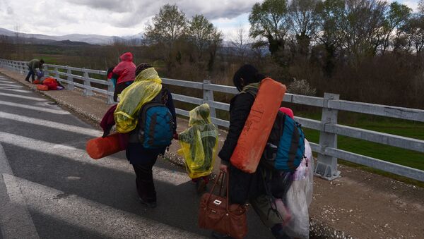 Newly arrived migrants walk towards the Greek-Macedonian border near the Greek village of Idomeni - Sputnik International