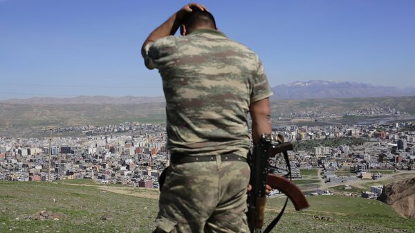A Turkish soldier gestures while standing on the hill overlooking damaged buildings following heavy fighting between government troops and Kurdish fighters in the Kurdish town of Cizre in southeastern Turkey, which lies near the border with Syria and Iraq, on March 2, 2016 - Sputnik International