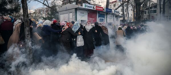 Smoke rises near a group of women as Turkish anti-riot police officers use tear gas to disperse supporters in front of the headquarters of the Turkish daily newspaper Zaman in Istanbul on March 5, 2016, after Turkish authorities seized the headquarters in a midnight raid - Sputnik International