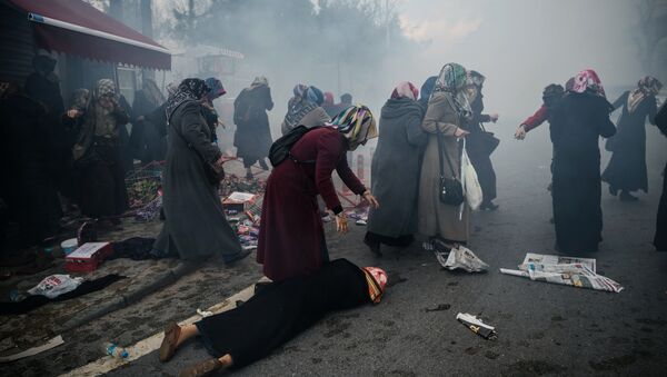 Women helps another woman who felt as Turkish anti-riot police officers launch tear gas to disperse supporters in front of the headquarters of the Turkish daily newspaper Zaman in Istanbul on March 5, 2016, after Turkish authorities seized the headquarters in a midnight raid - Sputnik International
