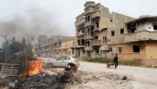A man pulls a wheelbarrow past destroyed buildings after clashes between military forces loyal to Libya's eastern government and Islamist fighters, in Benghazi, Libya, February 28, 2016. - Sputnik International