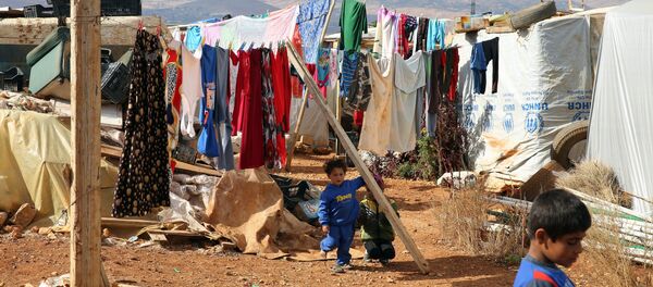 Syrian refugee children stand on November 15, 2015, at a makeshift camp by Taybeh village, in Lebanon's eastern Bekaa Valley Syrian refugee children stand on November 15, 2015, at a makeshift camp by Taybeh village, in Lebanon's eastern Bekaa Valley - Sputnik International