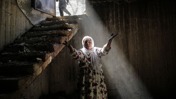 A woman reacts while walking among the ruins of damaged buildings following heavy fighting between government troops and Kurdish fighters, on March 2, 2016 in the southeastern Turkey Kurdish town of Cizre, near the border with Syria and Iraq - Sputnik International