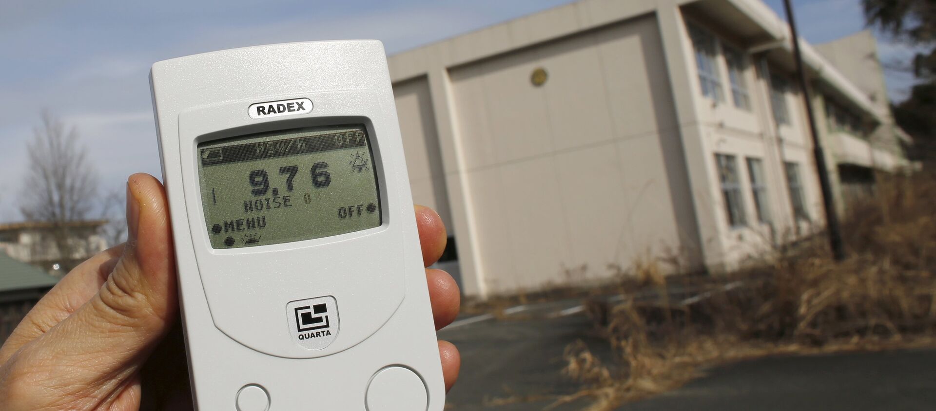 Reuters reporter measures a radiation level of 9.76 microsieverts per hour in front of Kumamachi Elementary School inside the exclusion zone in Okuma, near Tokyo Electric Power Co's (TEPCO) tsunami-crippled Fukushima Daiichi nuclear power plant, Fukushima Prefecture, Japan, February 13, 2016 - Sputnik International, 1920, 23.06.2018