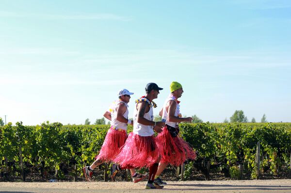 Men athletes dresses in colourful skirts run past Medoc's vineyards, near Pauillac, during the 30th Marathon du Medoc, a 26-mile (42.2km) circuit in the Medoc wine region near Bordeaux in south-western France which takes in more than 30 of the regions' chateaux and vineyards, on September 13, 2014 Men athletes dresses in colourful skirts run past Medoc's vineyards, near Pauillac, during the 30th Marathon du Medoc, a 26-mile (42.2km) circuit in the Medoc wine region near Bordeaux in south-western France which takes in more than 30 of the regions' chateaux and vineyards, on September 13, 2014 - Sputnik International