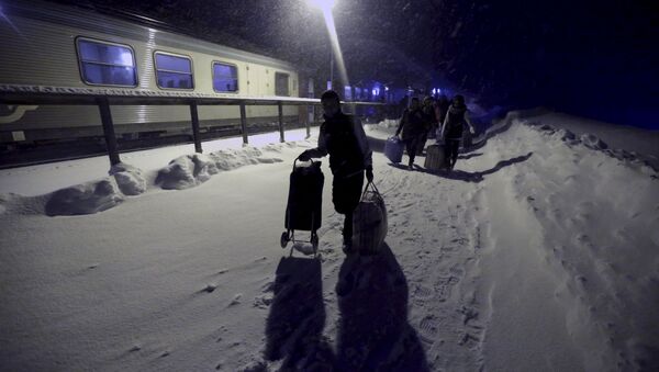 Refugees disembark and make their way to a camp at a hotel touted as the world's most northerly ski resort in Riksgransen, Sweden, in this December 15, 2015 file photo - Sputnik International