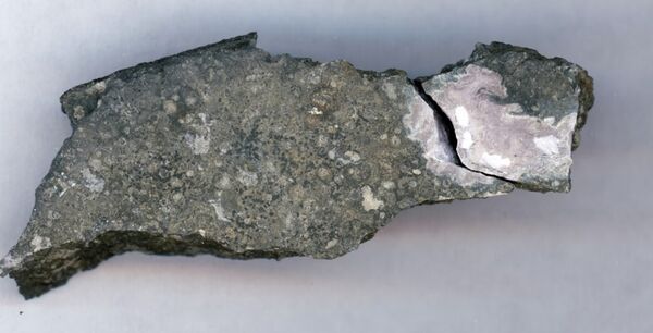 This close-up picture shows a ceramic-like refractory inclusion (pink inclusion) still embedded into the meteorite in which it was found   - Sputnik International