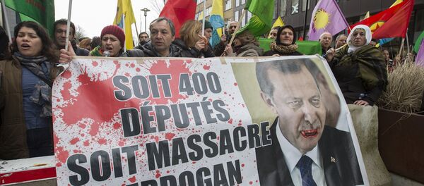 Kurdish people display a picture of Turkish President Tayyip Erdogan during a protest outside an EU-Turkey summit as the bloc is looking to Ankara to help it curb the influx of refugees and migrants flowing into Europe, in Brussels March 7, 2016 Kurdish people display a picture of Turkish President Tayyip Erdogan during a protest outside an EU-Turkey summit as the bloc is looking to Ankara to help it curb the influx of refugees and migrants flowing into Europe, in Brussels March 7, 2016 - Sputnik International