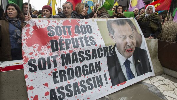 Kurdish people display a picture of Turkish President Tayyip Erdogan during a protest outside an EU-Turkey summit as the bloc is looking to Ankara to help it curb the influx of refugees and migrants flowing into Europe, in Brussels March 7, 2016 - Sputnik International