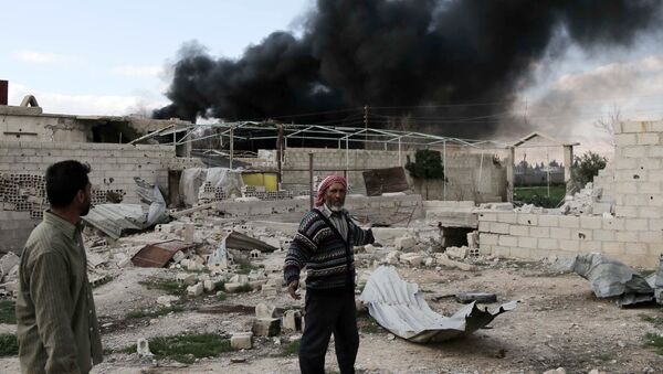 A Syrian man stands in the courtyard of his farm as smoke billows in the background following reported air strikes near the rebel-held village of al-Chifouniya, on the outskirts of the capital Damascus, on March 4, 2016 - Sputnik International
