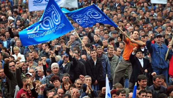 Workers wave trade-union flags and shout slogans as they protest in Pitesti, some 120km northwest from Bucharest, during a strike of the French-owned Romanian car plant Dacia on April 10, 2008 - Sputnik International