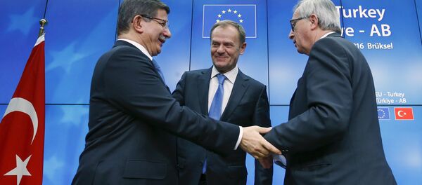 Turkish Prime Minister Ahmet Davutoglu (L), European Council President Donald Tusk (C) and European Commission President Jean Claude Juncker (R) greet each other after a news conference at the end of a EU-Turkey summit in Brussels March 8, 2016 - Sputnik International