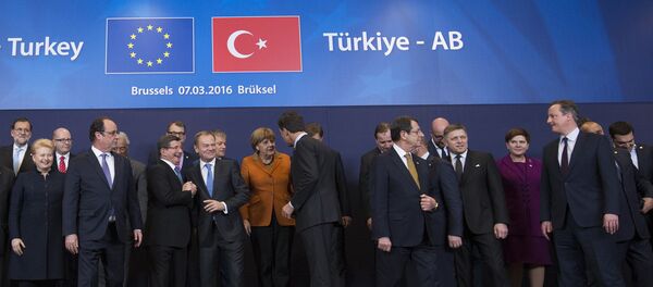 French President Francois Hollande (2nd L front row) looks on as Turkish Prime Minister Ahmet Davutoglu (3rd L) chats with European Council President Donald Tusk (4th L) while posing with European Union leaders during a EU-Turkey summit in Brussels, as the bloc is looking to Ankara to help it curb the influx of refugees and migrants flowing into Europe, March 7, 2016 - Sputnik International