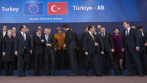 French President Francois Hollande (2nd L front row) looks on as Turkish Prime Minister Ahmet Davutoglu (3rd L) chats with European Council President Donald Tusk (4th L) while posing with European Union leaders during a EU-Turkey summit in Brussels, as the bloc is looking to Ankara to help it curb the influx of refugees and migrants flowing into Europe, March 7, 2016 - Sputnik International