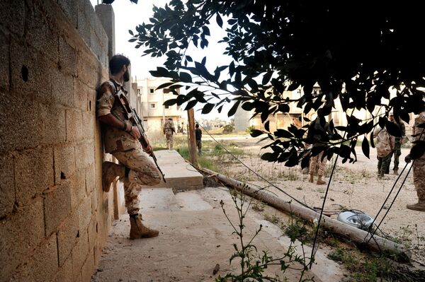 In this Monday, March 7, 2016 photo, men loyal to Libyan armed forces stand alert during clashes with Islamic State group militants west of Benghazi, Libya In this Monday, March 7, 2016 photo, men loyal to Libyan armed forces stand alert during clashes with Islamic State group militants west of Benghazi, Libya - Sputnik International