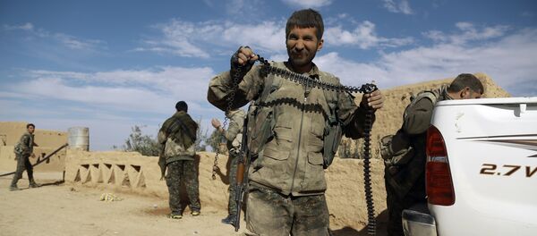 A fighter from the Syrian Democratic Forces (SDF) carries an empty ammunition belt upon his return from clashes in the town of al-Shadadi in the northeastern Syrian province of Hasakeh, on February 19, 2016 A fighter from the Syrian Democratic Forces (SDF) carries an empty ammunition belt upon his return from clashes in the town of al-Shadadi in the northeastern Syrian province of Hasakeh, on February 19, 2016 - Sputnik International