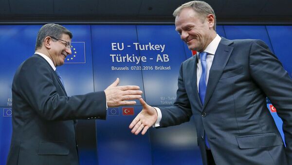 Turkish Prime Minister Ahmet Davutoglu (L) shakes hands with European Council President Donald Tusk after a news conference at the end of a EU-Turkey summit in Brussels March 8, 2016. - Sputnik International