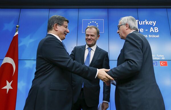 Turkish Prime Minister Ahmet Davutoglu (L), European Council President Donald Tusk (C) and European Commission President Jean Claude Juncker (R) greet each other after a news conference at the end of a EU-Turkey summit in Brussels March 8, 2016. Turkish Prime Minister Ahmet Davutoglu (L), European Council President Donald Tusk (C) and European Commission President Jean Claude Juncker (R) greet each other after a news conference at the end of a EU-Turkey summit in Brussels March 8, 2016. - Sputnik International